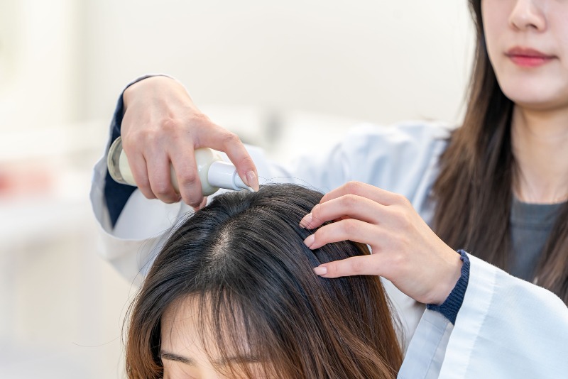 사진. 한국콜마 헤어연구팀 연구원이 스칼프 선에센스 테스트를 진행하고 있다.jpg